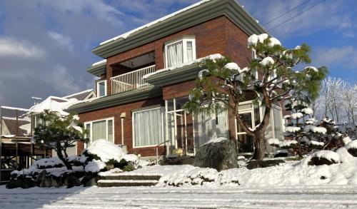 a house with snow in front of it at Frasis in Wada