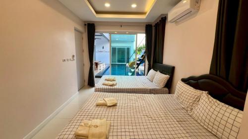 two beds in a room with towels on them at Cocktail Poolvilla Pattaya in Na Jomtien