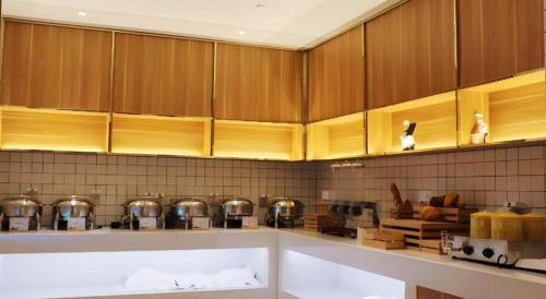 una cocina con armarios de madera, ollas y sartenes en Borrman Hotel Suzhou Wujiang Zhongshan North Road Pedestrian Street, en Suzhou