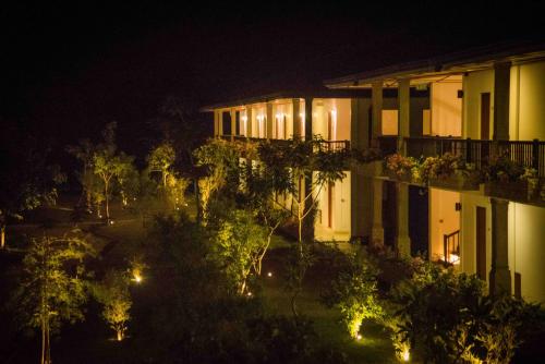 a night view of a building with trees and lights at Sungreen Resort Habarana in Habarana