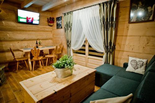 a living room with a couch and a table at Domki Prokop in Ciche