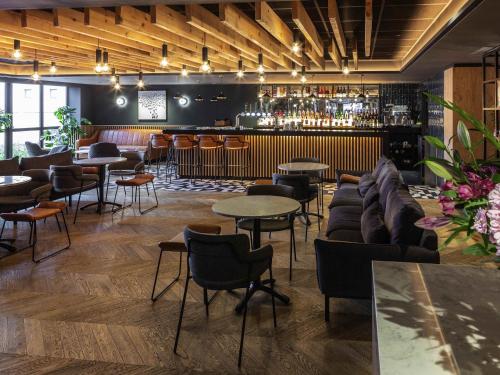 Un bar con sofás y mesas en una habitación. en Novotel Birmingham Airport Terminal Building - NEC, en Bickenhill