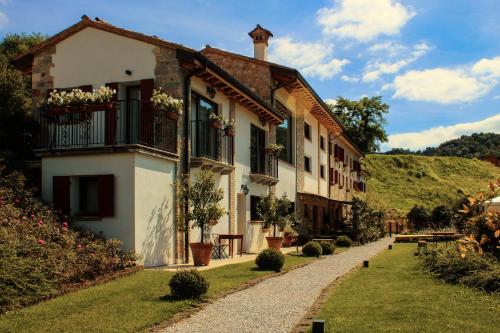 a building with flowers on the balconies and a pathway at Ca' Piadera Wine Relais in Tarzo