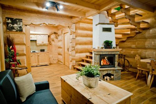 a living room with a fireplace in a log cabin at Domki Prokop in Ciche