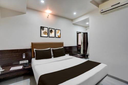 Кровать или кровати в номере Hotel O Sur Sagar Lakeview Vadodara Formerly Vintage Inn