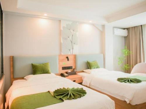 Una cama o camas en una habitación de GreenTree Inn Express Hainan Haikou Haixiu Zhong Road