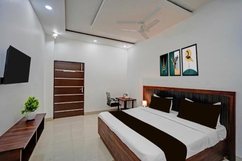a bedroom with a large bed and a tv at Hotel O Sector 110 Noida Formerly Luv Kush Tower Bhangel in Noida