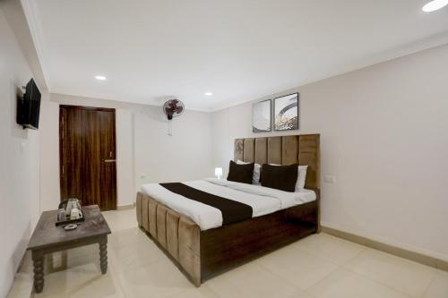 a bedroom with a large bed and a table at Collection O Civil Lines Prayagraj in Prayagraj