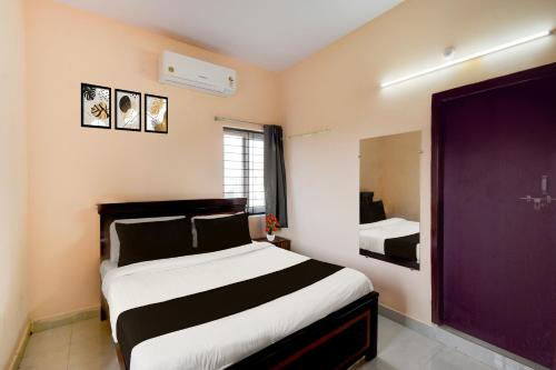 a bedroom with a large bed and a purple door at Super Hotel O Bharat Institute of Engineering Hyderabad Formerly Blue Petals in Hyderabad