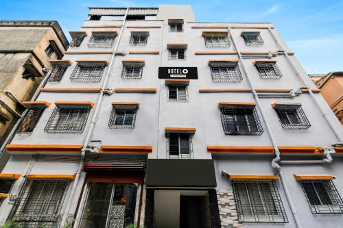 um prédio alto e branco com uma placa em Hotel O Narayana RN Tagore Hospital Formerly Lantern Guest House em Calcutá