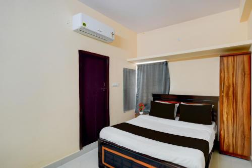 a bedroom with a large bed with black and white sheets at Super Hotel O Bharat Institute of Engineering Hyderabad Formerly Blue Petals in Hyderabad