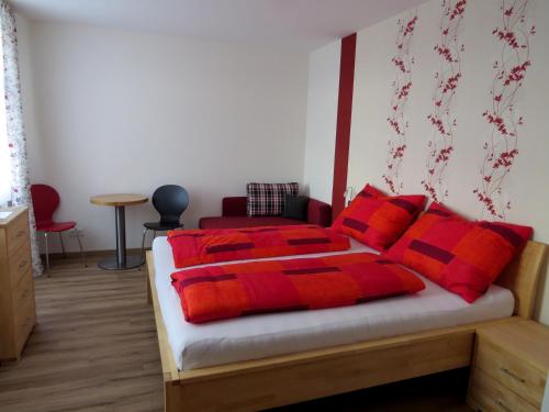 Schlafzimmer mit einem Bett mit roten und schwarzen Kissen in der Unterkunft Gasthof Christine Enne in Albrechtsberg an der Grossen Krems