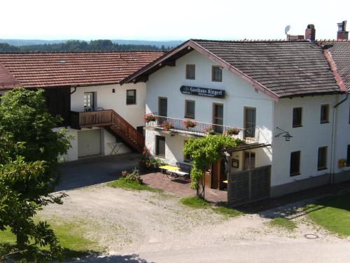 a large white building with a bridge in front of it at Gasthaus Hingerl in Obing