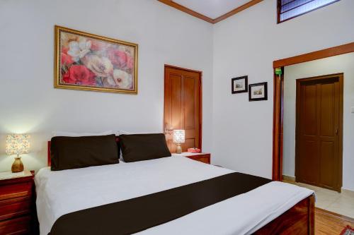 Midhill Cottage by Palette | Garden | Indoor Games | Shillong في شيلونغ: غرفة نوم بها سرير ولوحة على الحائط