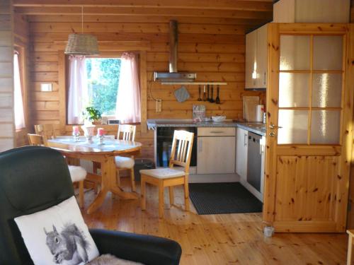 uma cozinha e sala de jantar com uma mesa num camarote em Ferienhaus Berg.erleben em Hilders