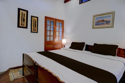 Midhill Cottage by Palette | Garden | Indoor Games | Shillong في شيلونغ: غرفة نوم بها سرير كبير في الغرفة