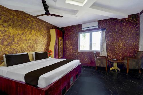 a bedroom with a bed in a room with wallpaper at Collection O Sirkazhi Formerly Navagiraga Resort in Vaithīsvarankoil
