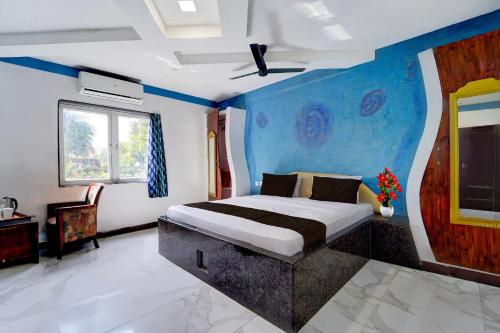 a bedroom with a bed with a blue wall at Collection O Sirkazhi Formerly Navagiraga Resort in Vaithīsvarankoil