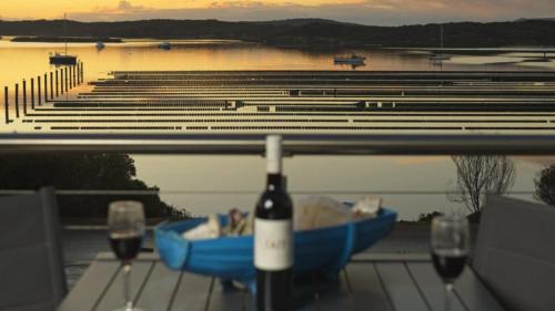 a bottle of wine sitting on a table with two glasses at Seascape in Coffin Bay