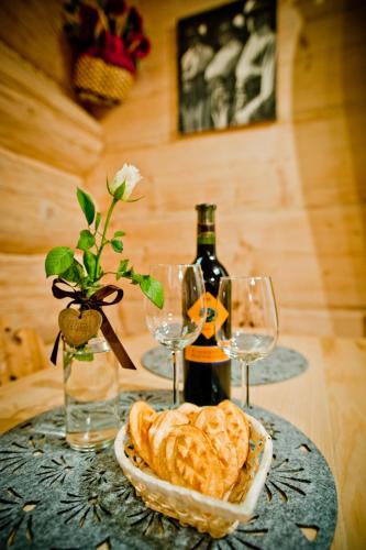 a table with a plate of bread and wine glasses at Domki Prokop in Ciche