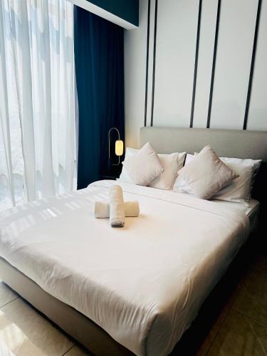 Una cama blanca grande con dos toallas encima. en Bukit Bintang Suites KL, en Kuala Lumpur