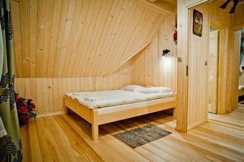 a bedroom with a bed in a wooden room at Domki Prokop in Ciche