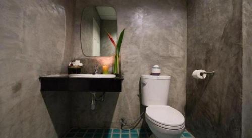 a bathroom with a toilet and a sink and a mirror at The Forest Home Resort in Ban Dong