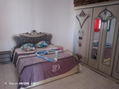 Appartement 5 Midoun centre في تاجورميس: غرفة نوم مع سرير مع لوح خشبي للرأس
