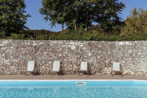 
two wooden benches in front of a stone wall at AHG Donna Silvia Hotel Wellness & SPA in Manerba del Garda
