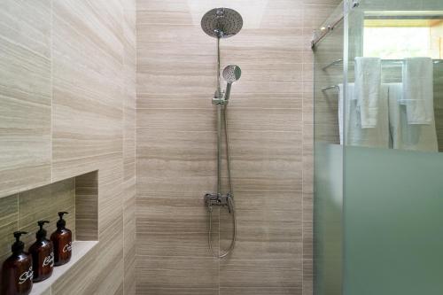 a shower with a shower head in a bathroom at Diwangkara Villa Pandawa in Ungasan