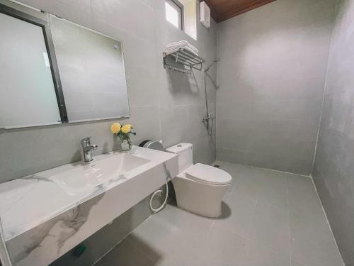 a bathroom with a toilet and a sink and a mirror at The Sam Home in Nguyên Ngoại