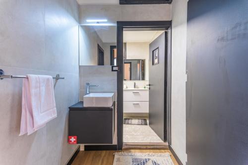 Residence 4 - Comfy Apts & Balconies in Mar Mikhael في Al Mudawwar: حمام مزود بحوض ومِرآة