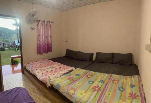 Giường trong phòng chung tại LungKola Homestay, Pang Ung, Mae Hong Son ลุงกอละ โฮมสเตย์ ปางอุ๋ง