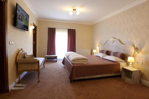 a hotel room with a bed and a chair at Hotel Green Garden in Shumen