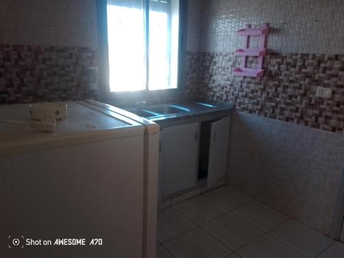 Appartement 5 Midoun centre في تاجورميس: حمام صغير مع حوض ونافذة