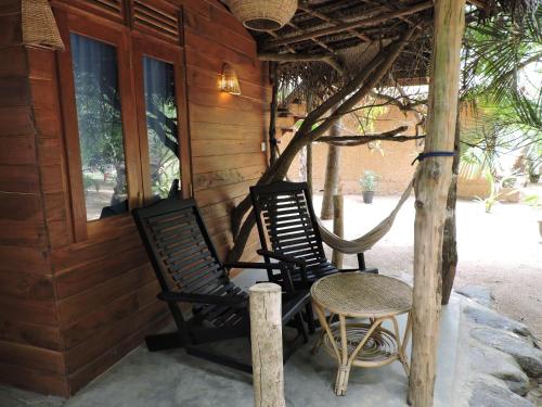 two chairs and a table on the porch of a house at Cinnabar Resort in Tangalle