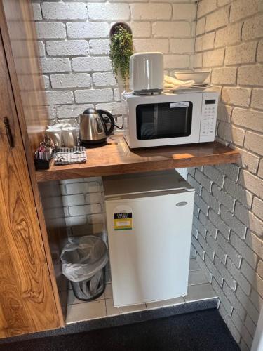 a microwave sitting on top of a small refrigerator at Cessnock Vintage motor inn in Cessnock
