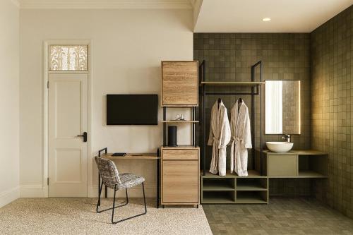 ein Zimmer mit einem Schreibtisch, einem Stuhl und einem Fernseher in der Unterkunft Commercial Hotel Boonah in Boonah