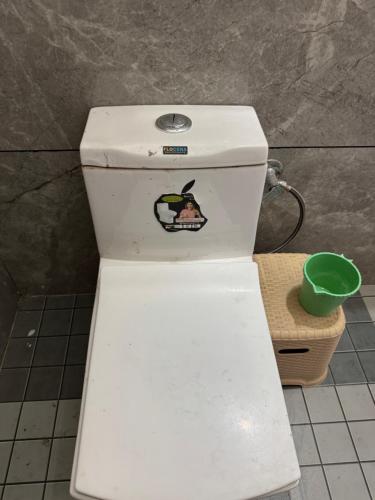 een toilet met een sticker op de achterkant bij Takery Resort in Chittaurgarh