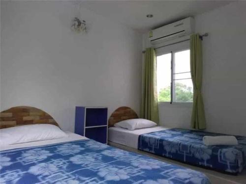 a bedroom with two beds and a window at White Rock Resort Pakchong in Ban Nong Ka Cha