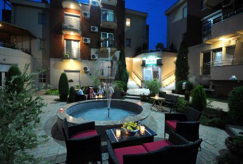 a courtyard with a fountain in front of a building at IWA CENTAR Apartments & Wellness in Vrnjačka Banja