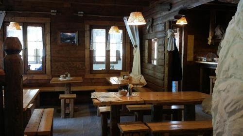 a dining room with wooden tables and windows at Eirl DOLOMITES Retreat Sappada in Sappada