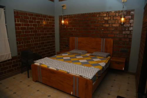 a bedroom with a bed in a brick wall at The Loft -Aadhya Homestay Hampi in Munirābād