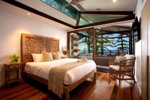 Luxury On The Bay - 2 x 3 bedroom apartments في خليج بايرون: غرفة نوم بسرير كبير ونافذة كبيرة