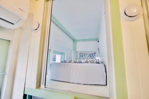 a bedroom in a tiny house with a mirror at Easy Monday Capsule Hotel Bangkok in Bangkok