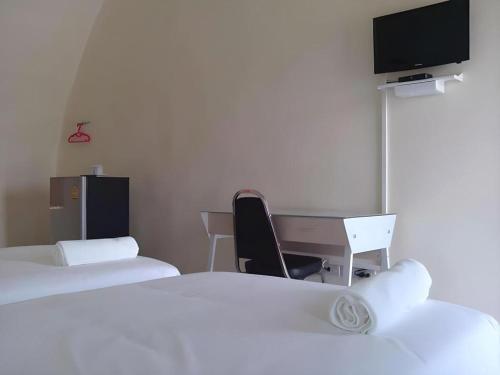 a room with two beds and a desk and a tv at Eskimo Resort in Ban Pa Kruat