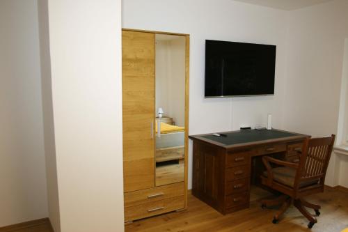 Zimmer mit einem Schreibtisch und einem TV an der Wand in der Unterkunft Vlotho Apartment in Vlotho