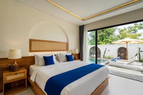 a bedroom with a large bed and a large window at Diwangkara Villa Pandawa in Ungasan