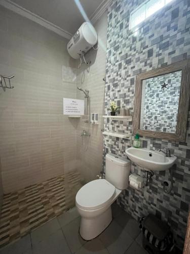 a bathroom with a toilet and a sink at VnS Beachfront Guesthouse in Nusa Penida