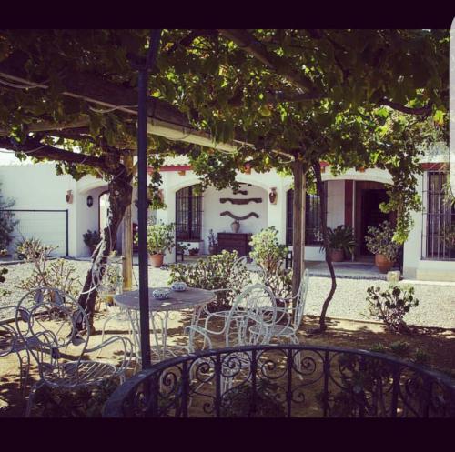 a patio with a table and chairs under a pergola at Molino La Boticaria in Marchena